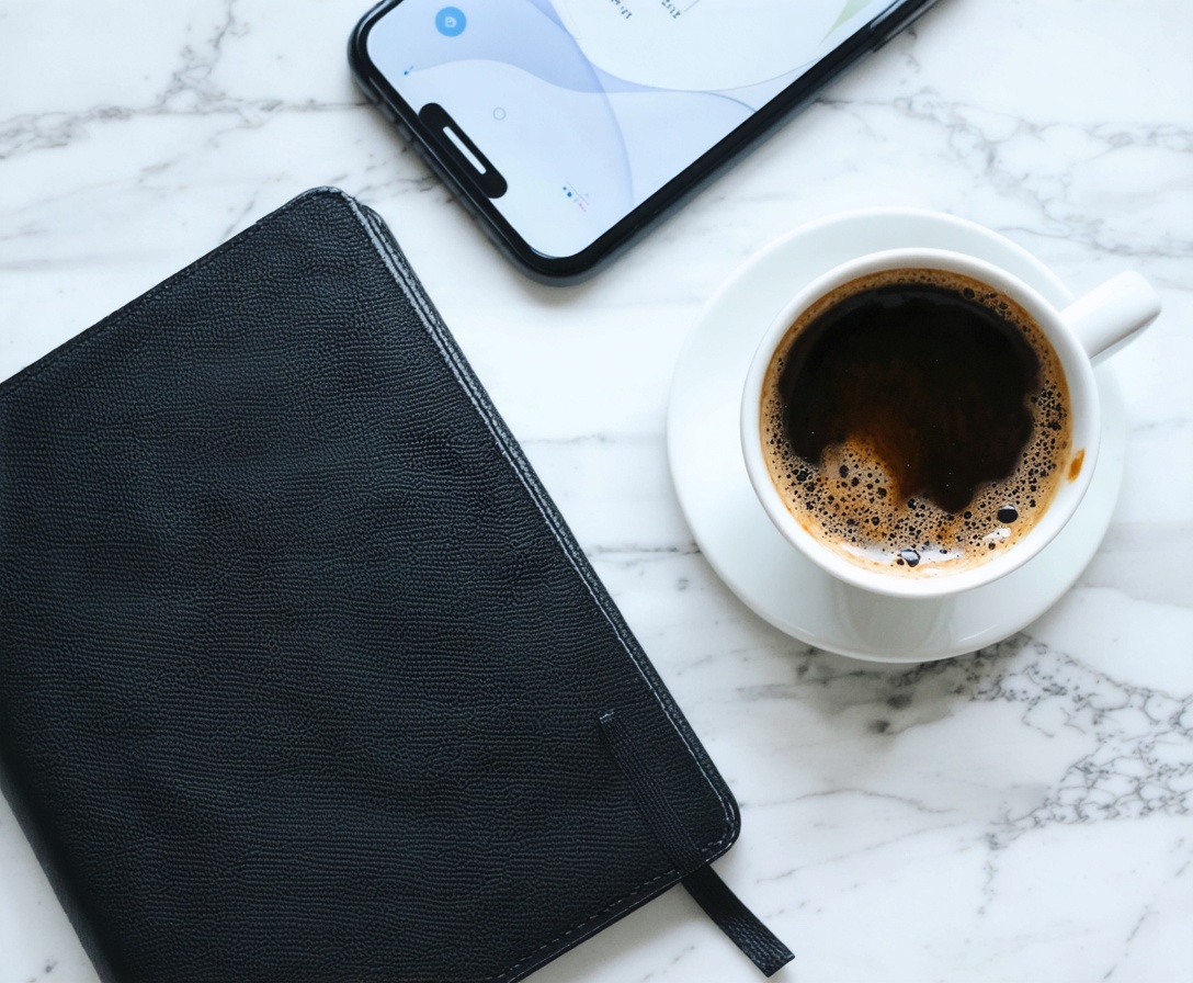 Plánovač a káva na mramorovom stole